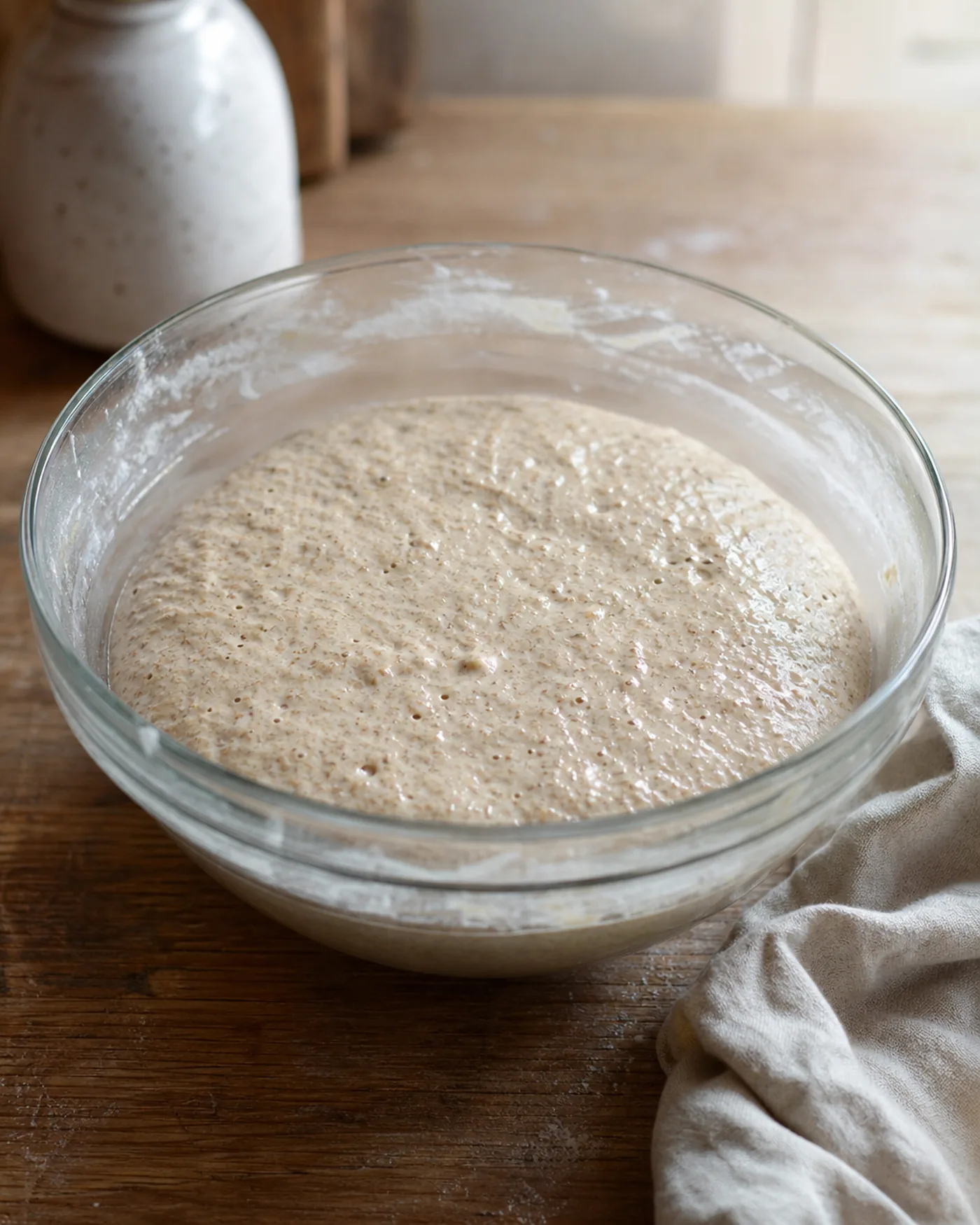 Pâte de seigle humide en fermentation avec de petites bulles visibles dans un saladier.