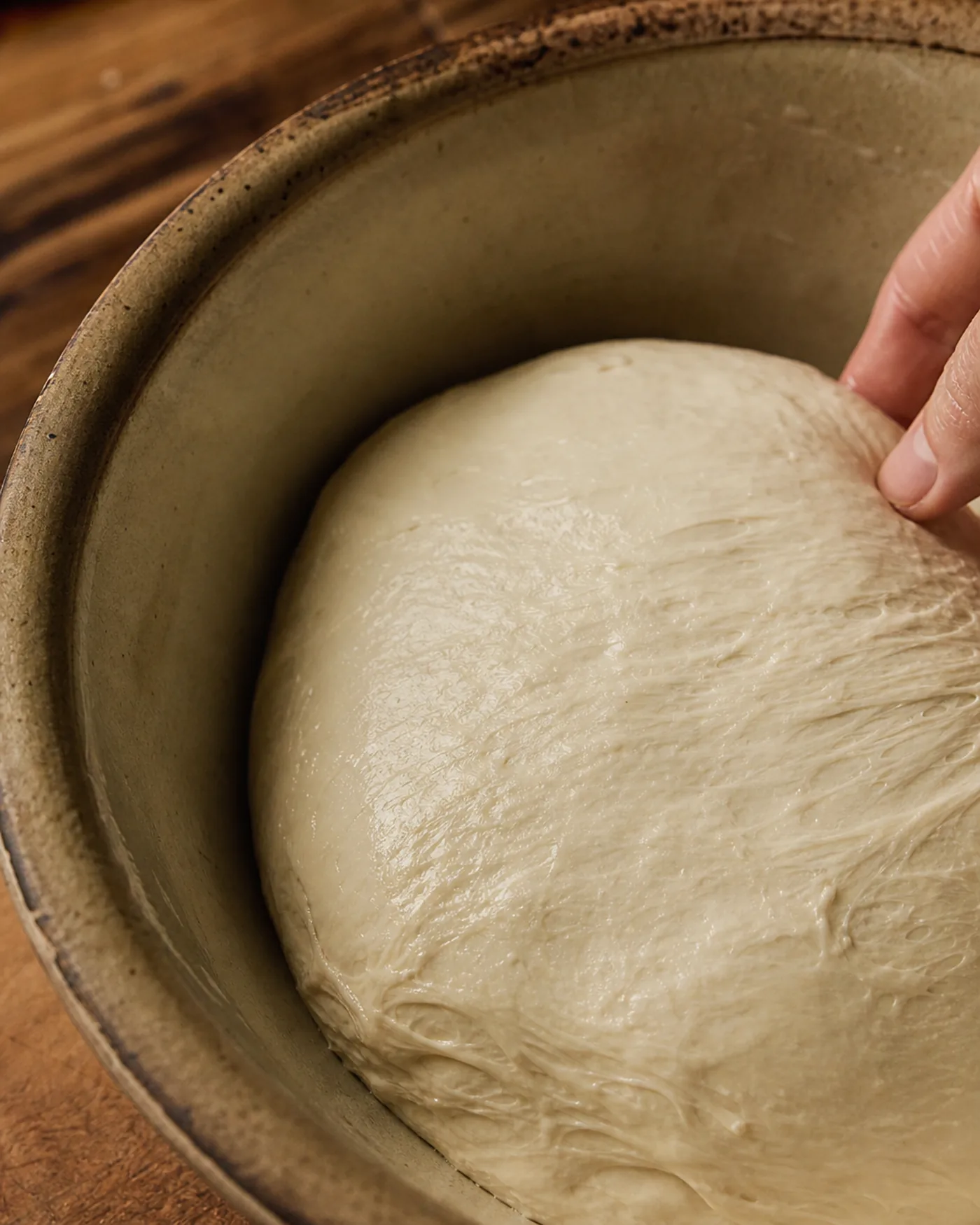 Gros plan sur une pâte lisse et élastique après autolyse, surface brillante montrant le développement du gluten